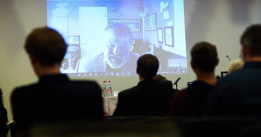 Paul on screen with audience behind-1